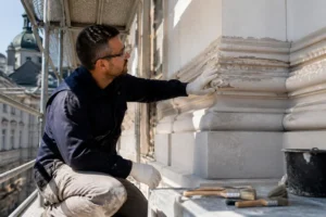 Handwerker inspiziert Fassade bei einer kompletten Renovierung eines Altbaus in Solingen.